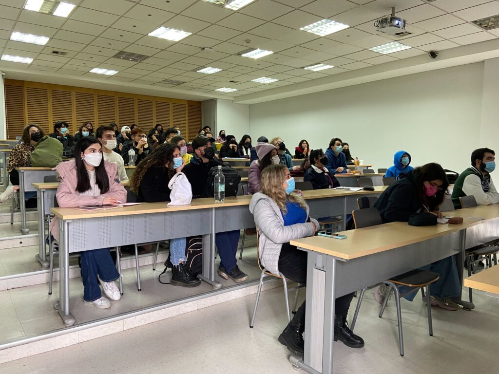 Estudiantes sentados en una sala escuchando una charla sobre intercambio bilateral